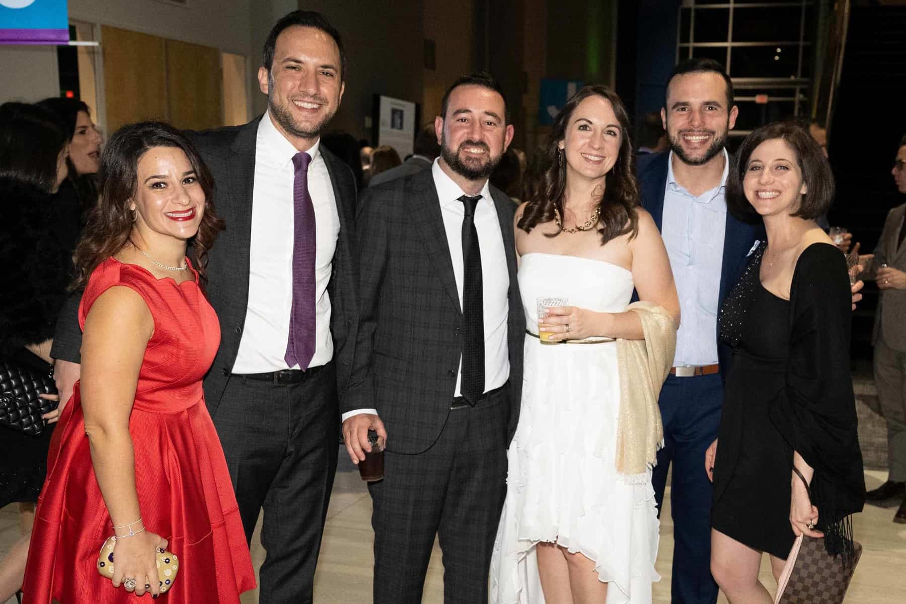 six adults standing and smiling for photo at gala